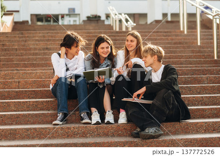 Under sunlight, sitting. Group of students are near university together 137772526