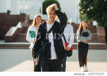 At sunny day, standing. Group of students are near university together At sunny day, standing. Group of students are near university together 137772537