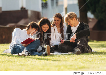Exam preparation, sitting and learning. Group of students are near university together 137772549