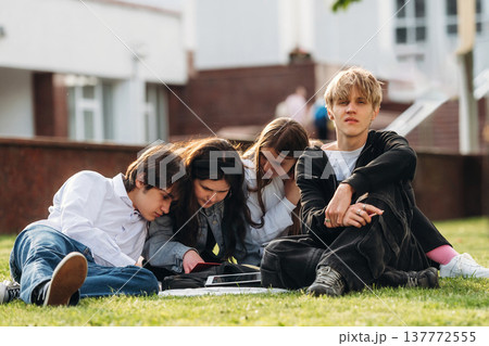 Exam preparation, sitting and learning. Group of students are near university together Exam preparation, sitting and learning. Group of students are near university together 137772555
