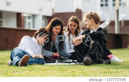 Exam preparation, sitting and learning. Group of students are near university together Exam preparation, sitting and learning. Group of students are near university together 137772556
