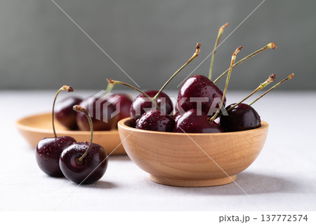 Fresh red cherries with water droplets in a wooden bowl Fresh red cherries with water droplets in a wooden bowl 137772574
