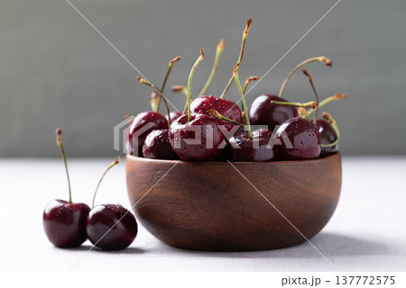 Fresh red cherries with water droplets in a wooden bowl Fresh red cherries with water droplets in a wooden bowl 137772575