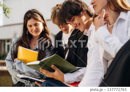 Boys and girls are sitting. Group of students are near university together 137772765