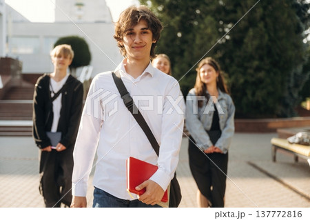 White shirt, positive facial expression. Group of students are near university together 137772816