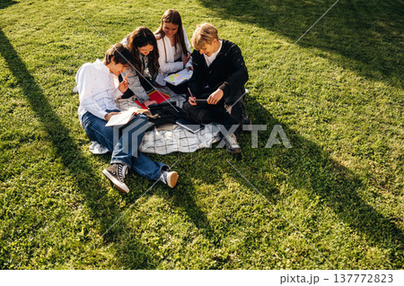 Sitting on the ground. Friends students are together outdoors 137772823