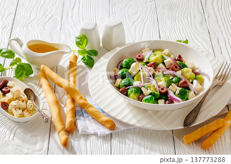 brussels sprouts salad with feta, olives in bowl 137773288