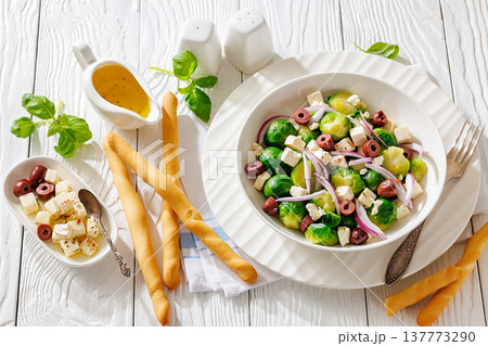 brussels sprouts salad with feta, olives in bowl 137773290