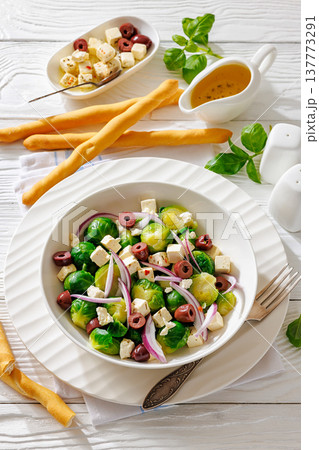 brussels sprouts salad with feta, olives in bowl 137773291