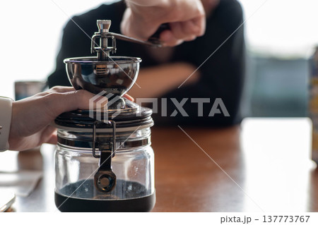手挽きコーヒーミルで豆を挽くシーン 137773767