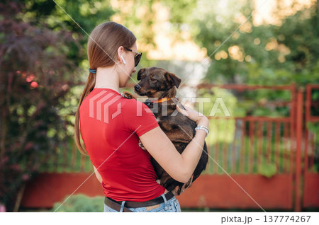 In sunglasses. Woman in red clothes is with dog outdoors 137774267