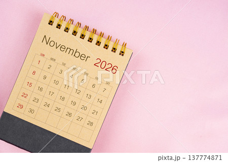Brown desk calendar for November 2026 on pink background. 137774871