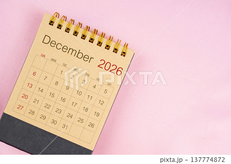 Brown desk calendar for December 2026 on pink background. 137774872