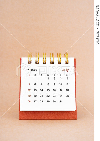 July 2026 white desk calendar on brown background. 137774876
