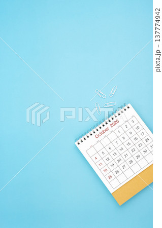 Desk calendar for October 2026 and white paper clip on a light blue background. Desk calendar for October 2026 and white paper clip on a light blue background. 137774942