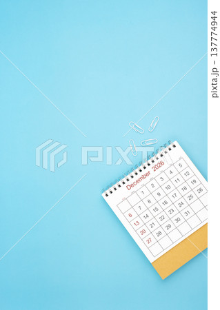Desk calendar for December 2026 and white paper clip on a light blue background. Desk calendar for December 2026 and white paper clip on a light blue background. 137774944