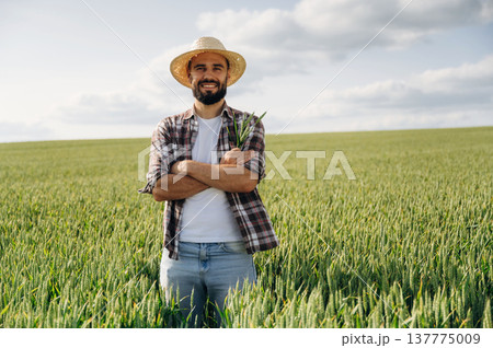 Positive facial expression, smiling. Man farmer is on the agricultural field 137775009