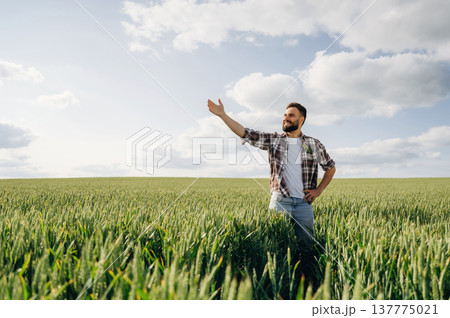 Showing the place by hand. Man farmer is on the agricultural field Showing the place by hand. Man farmer is on the agricultural field 137775021