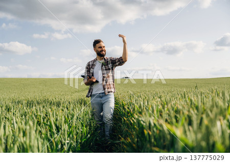 Showing the place by hand. Man farmer is on the agricultural field 137775029