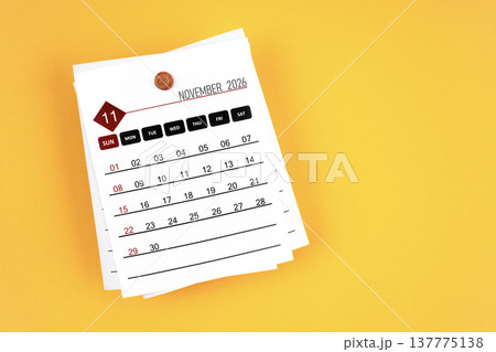 November 2026 calendar page with wooden push pin on yellow, position with copy space. November 2026 calendar page with wooden push pin on yellow, position with copy space. 137775138