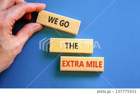 Support, help we go the extra mile symbol. Concept words We go the extra mile on beautiful wooden blocks. Beautiful blue background. Business we go the extra mile concept. Copy space. 137775931