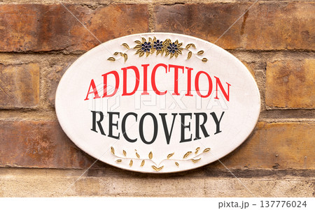 Addiction recovery symbol. Concept words Addiction recovery on beautiful big white sign plate. Beautiful old brown brick wall background. Psychology addiction recovery concept. Copy space. Addiction recovery symbol. Concept words Addiction recovery on beautiful big white sign plate. Beautiful old brown brick wall background. Psychology addiction recovery concept. Copy space. 137776024