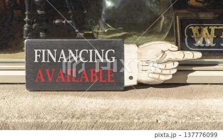 Financing available symbol. Concept words Financing available on beautiful wooden black sign as a hand. Beautiful store display background. Business financing available concept. Copy space. Financing available symbol. Concept words Financing available on beautiful wooden black sign as a hand. Beautiful store display background. Business financing available concept. Copy space. 137776099
