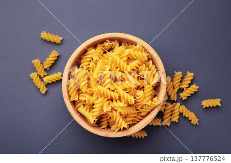 Bowl of raw fusilli pasta on dark blue background 137776524