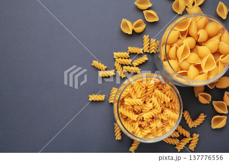 Different types of pasta in glass jars on dark blue background 137776556