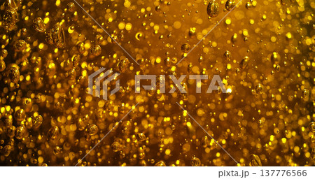 Abstract golden bubbles rising in liquid with sparkling highlights and soft bokeh. Macro texture resembling carbonation in beer, champagne or sparkling beverage creating a luxurious glowing backgrou Abstract golden bubbles rising in liquid with sparkling highlights and soft bokeh. Macro texture resembling carbonation in beer, champagne or sparkling beverage creating a luxurious glowing backgrou 137776566