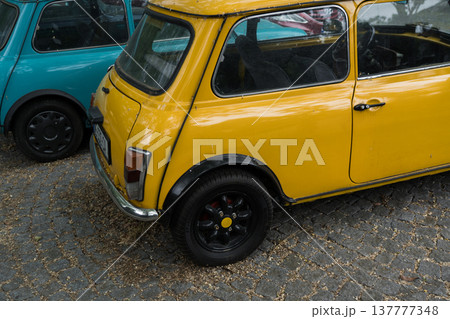 A bright yellow, small old car stands in a parking lot in Batumi, Georgia 137777348