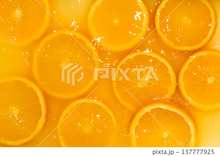 Fresh slices of oranges splashing in orange juice. Fruity bright background Fresh slices of oranges splashing in orange juice. Fruity bright background 137777925