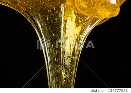 Macro Texture Of Liquid Fresh Honey On Black Background. Macro Texture Of Liquid Fresh Honey On Black Background. 137777928