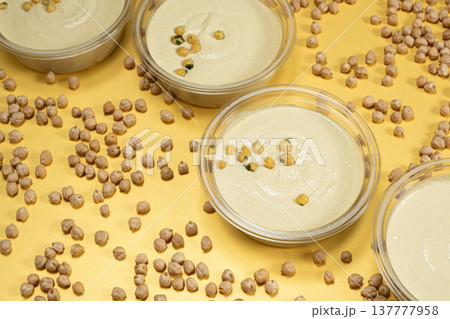 Hummus bowls with whole chickpeas on yellow background. Hummus bowls with whole chickpeas on yellow background. 137777958