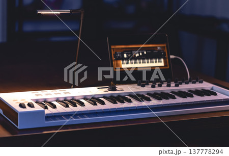 Musical keyboard and tablet in a dark room, music production. Musical keyboard and tablet in a dark room, music production. 137778294