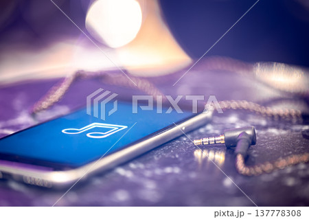 Close up of phone screen with music icon and headphone jack. 137778308