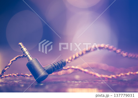 Headphone jack on blurred background with stage lighting. 137779031