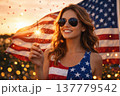 Smiling Woman with Sparkler and American Flag at Sunset Celebration 137779542