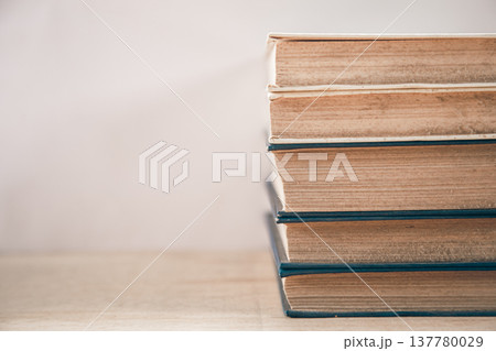 Old books stacked on a white background. 137780029