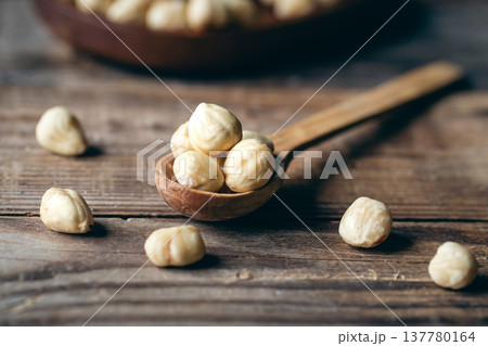 Peeled hazelnuts in a wooden spoon, close-up. Peeled hazelnuts in a wooden spoon, close-up. 137780164