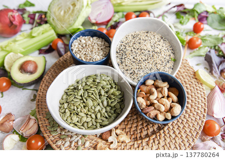 Pumpkin seeds, nuts and chia seeds and other healthy foods on the kitchen table. 137780264