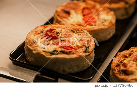 Small puff pies with vegetables and meat, quiches in a cafe window. Small puff pies with vegetables and meat, quiches in a cafe window. 137780460