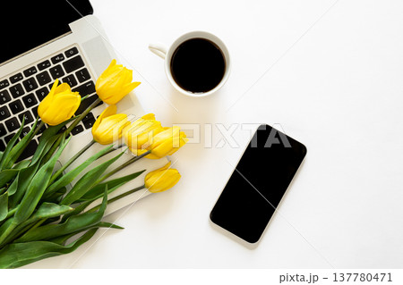 Smartphone, cup of coffee, laptop and a bouquet of tulips on a white background. Smartphone, cup of coffee, laptop and a bouquet of tulips on a white background. 137780471