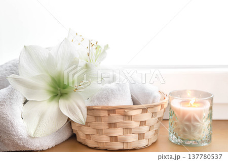 Spa composition with lily flowers and towels in a basket. 137780537