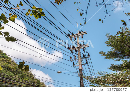 Power lines and electric pole against blue tropical sky 137780977