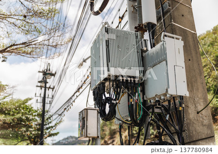 Telecommunication network equipment and antennas installed on concrete utility pole in tropical Thailand Telecommunication network equipment and antennas installed on concrete utility pole in tropical Thailand 137780984