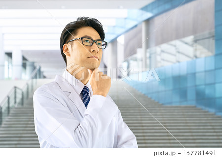 病院のホールで真剣に思案する若い男性医師 白衣の医者 診断 治療方針 課題 未来の医療 137781491