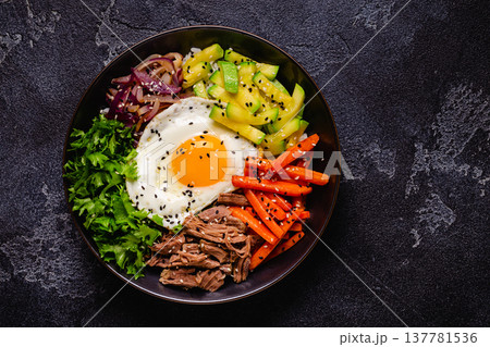 Traditional Korean dish Bibimbap: rice with vegetables beef and egg. Traditional Korean dish Bibimbap: rice with vegetables beef and egg. 137781536