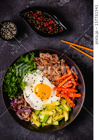 Traditional Korean dish Bibimbap: rice with vegetables beef and egg. 137781541