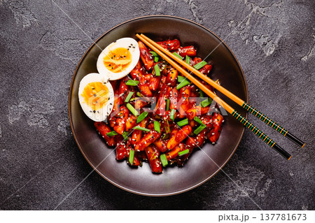 Tteokbokki, Teopokki fried rice cake in black bowl. Tteokbokki, Teopokki fried rice cake in black bowl. 137781673